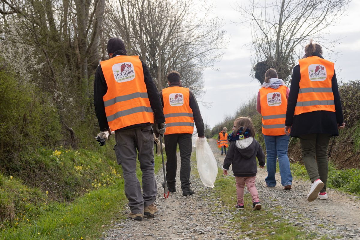 Une famille participant à l'opération de ramassage de déchets dans la nature: J'aime la nature propre